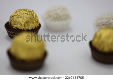 Beautiful of white and dark chocolate ball shaped candies with filling, nuts and coconut shavings isolated on white background. Full sharpness across the entire field of the frame.