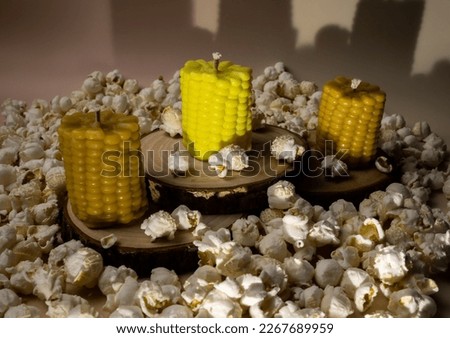 Product photography of corn-shaped candles among popcorn