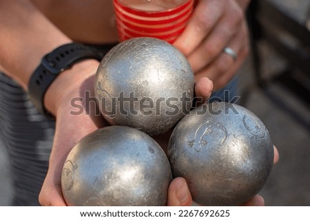 hand holding set of petanque balls