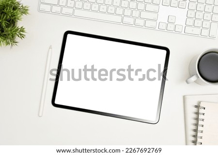 White workspace top view with keyboard, stylus pen, coffee cup, decor and digital tablet white screen mockup.