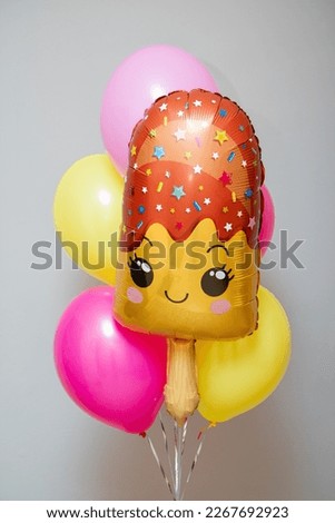 A set of yellow and pink balloons and an ice cream balloon. Decorations from balloons for a birthday for a girl