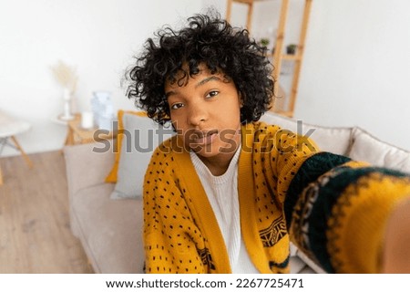 Happy african american teen girl blogger smiling face talking to webcam recording vlog. Social media influencer woman streaming making video call at home. Headshot portrait selfie webcamera view Royalty-Free Stock Photo #2267725471