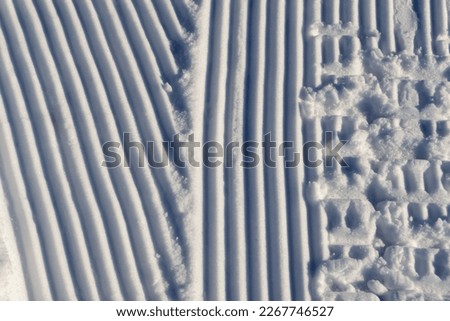 Striped plowing marks in the snow. Picture taken at sunny winter day.