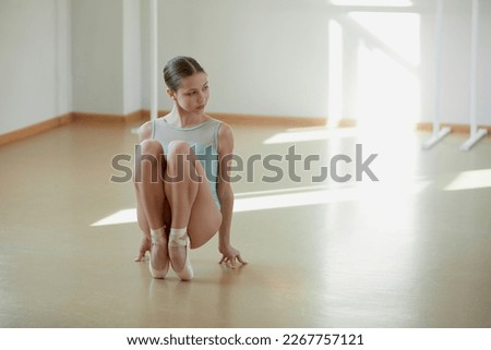 Beautiful teen girl, professional ballerina dancer training at ballet school on daytime. Tenderness and grace. Concept of classical ballet, dance art, education, beauty, choreography