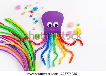 Funny octopus made of beads and pipe cleaners with different colorful and materials for DIY art activity for kids. Cute children's crafts, creativity and hobby. Development of fine motor skills Royalty-Free Stock Photo #2267760361