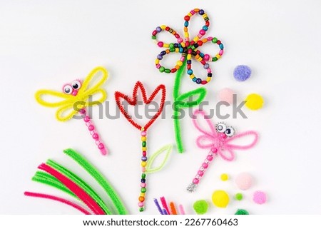 Beaded Pipe Cleaner flowers and dragonflies. Easy spring kids crafts. Different multi-colored supplies and materials for DIY art activity for kids. Children's crafts, creativity and  hobby.  Royalty-Free Stock Photo #2267760463