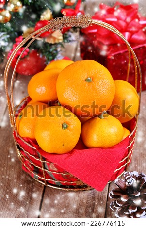 Mandarins in a golden  basket and Christmas decorations