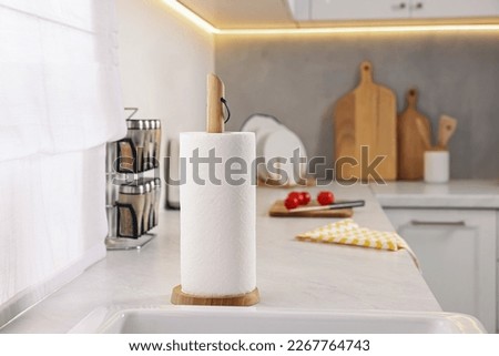 Roll of paper towels on white countertop in kitchen, space for text Royalty-Free Stock Photo #2267764743