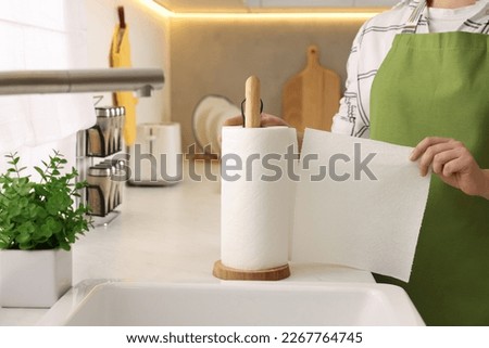 Woman using paper towels in kitchen, closeup Royalty-Free Stock Photo #2267764745