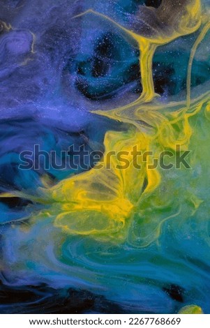 Photo of beautiful mixtures of colorful substances in the dark. Abstract texture of colorful splashes. Expressive swirls.
