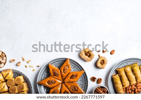 Arabian Baklava with nuts and honey on white background, copy space, top view. Ramadan dessert - fresh assorted nut baklava. Royalty-Free Stock Photo #2267771597