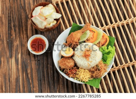 Top Vie Nasi Uduk, Typical Indonesian Food for Breakfast. Steamed Rice Cooked with Coconut Milk, Served with Fried Chicken. Eggs, Tempeh Oreg, and Bihun Royalty-Free Stock Photo #2267785285