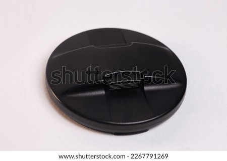 black protective cover for the camera lens, isolated on a white background.