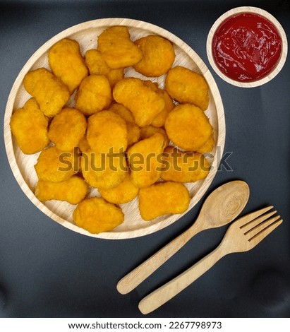 Chicken nuggets with ketchup on black background. Fast food
