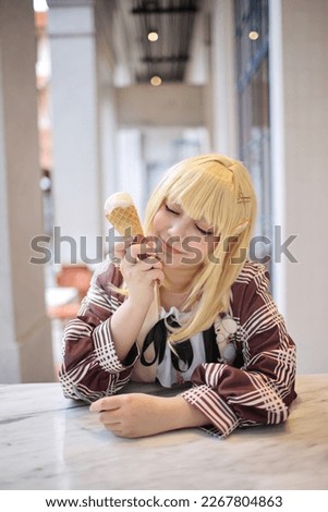 Portrait of a beautiful young woman game Cosplay with blonde hair with ice cream