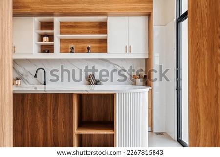 Modern kitchen design . Combination of white scheme with touch of timber giving the space warm vibes Royalty-Free Stock Photo #2267815843