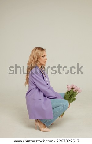 Young beautiful blonde woman with a bouquet of tulips