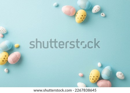 Easter decor concept. Top view photo of composition of pink blue and yellow easter eggs on isolated pastel blue background with copyspace in the middle