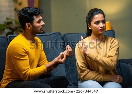 Girl or wife saying no husband trying to convince at home - concept of break up, conflict and disagreement Royalty-Free Stock Photo #2267844349