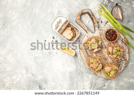 Sandwich with cod liver pate on a wooden board. banner, menu, recipe place for text, top view.
