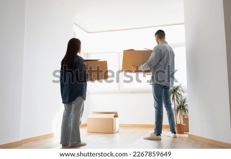 Young Couple Moving Home Together, Carrying Big Cardboard Boxes In Hands, Millennial Spouses Standing In Empty Room, Thinking Where To Place Belongings After House Relocation, Copy Space Royalty-Free Stock Photo #2267859649