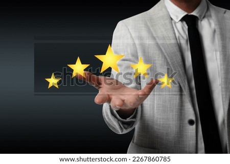 Quality evaluation. Businessman showing virtual golden stars on black background, closeup