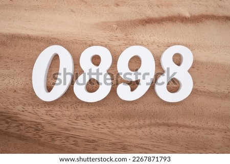 White number 0898 on a brown and light brown wooden background.