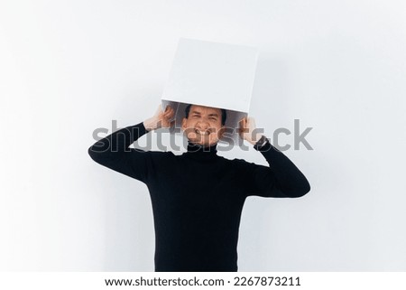 Think outside or inside the box concept. Isolated agaist a white background person with a white box on his head.