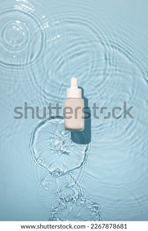 Serum Bottle on water ripple surface. dropper on blue background with ocean effect.