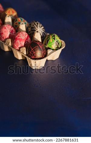 Colorful Easter eggs on blue background. Traditional Ukrainian pysanka handmade technique. DIY festive symbols. Spring holiday decoration background. Happy Easter.