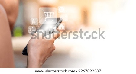 A girl holding a phone with virtual icons displayed above the phone. Online store shopping cart icon. Royalty-Free Stock Photo #2267892587