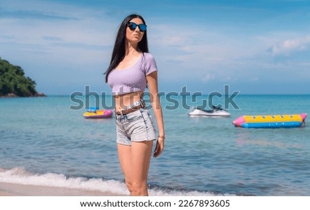 Summer lifestyle portrait of young girl enjoying on the tropical island. In the background the sea. Wearing Crop tops and shorts relaxed, Straight long hair.summer travel concept.