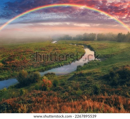 Amazing rainbow over the small rural river. autumn morning. nature of Ukraine


