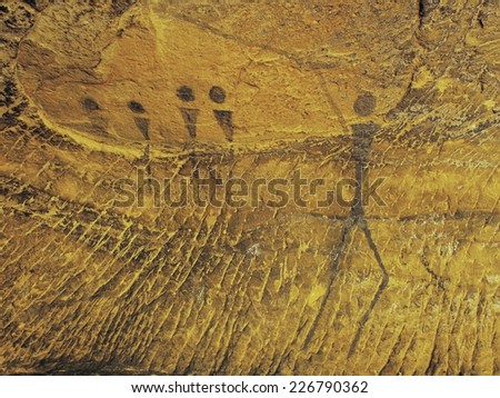 Abstract children art in sandstone cave. Black carbon paint of human hunting on sandstone wall, copy of prehistoric picture. 