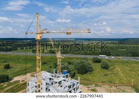 Tower crane builds a residential building, aerial photography.Tower crane and unfinished residential building. Housing construction, apartment buildingBuilding construction.Construction concept.