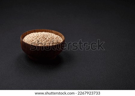 Wholesome raw quinoa in a bowl on a dark concrete background. Useful healthy food