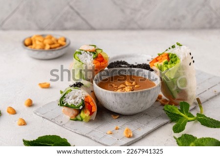 Summer rolls with fresh vegetables and shrimps and peanut sauce. Vietnamese appetizer. Salad spring rolls with prawns. Healthy food concept