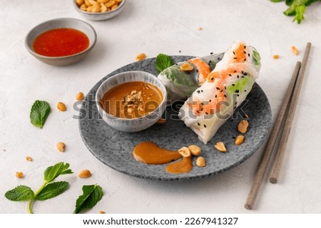 Summer rolls with fresh vegetables and shrimps and peanut sauce. Vietnamese appetizer. Salad spring rolls with prawns. Healthy food concept Royalty-Free Stock Photo #2267941327
