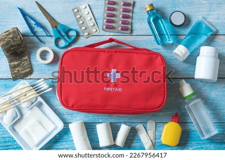 First aid kit with medical equipment and emergency objects at home or travel set ,copy space,top view,flat lay on wood background Royalty-Free Stock Photo #2267956417