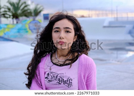 Portrait of teenage girl dressed in gothic style posing in skate park