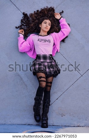 Top view image of teenage girl in gothic style lying on the ground.