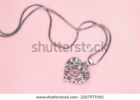 Silver heart necklace on pink background closeup Royalty-Free Stock Photo #2267971961
