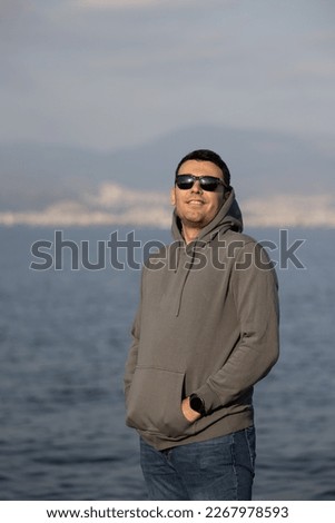 Young handsome man with sunglasses by sea.
