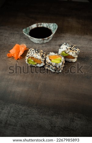 salmon and avocado sushi with seeds. studio shot. 3 pieces and soy sauce