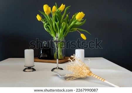 sprinkler and holy water on a wedding blessing on the table with candles, crucifix and bouquet of yellow tulips