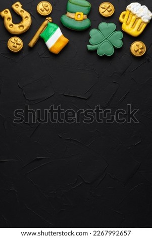 Vertical banner for St. Patrick's Day on dark concrete background. Coins, horseshoes, four-leaf clover as symbols of the holiday. Place for text.