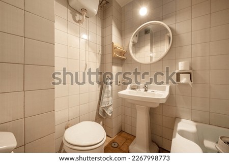 Old-style bathroom with white tiles, vintage porcelain sinks, and a small bathtub
