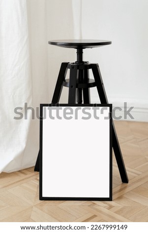 Vertical black frame mockup on the wooden floor. Studio minimalist interior art