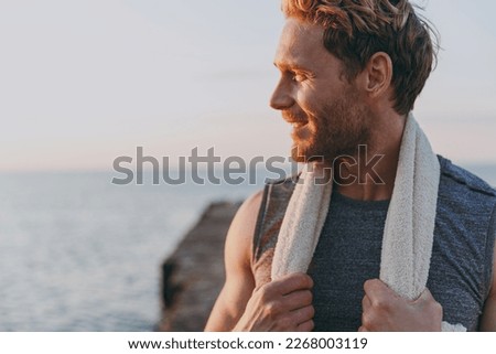 Close up happy young strong sporty athletic toned fit sportsman man in sports clothes towel warm up train look aside at sunrise sun dawn over sea beach outdoor on pier seaside in summer day morning. Royalty-Free Stock Photo #2268003119