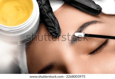Eyebrows tattoo or Permanent Makeup. Detail of beautiful woman, eyebrow with nice black Brows In Beauty Salon. Beauty eyebrow upgrade procedure. Royalty-Free Stock Photo #2268003975